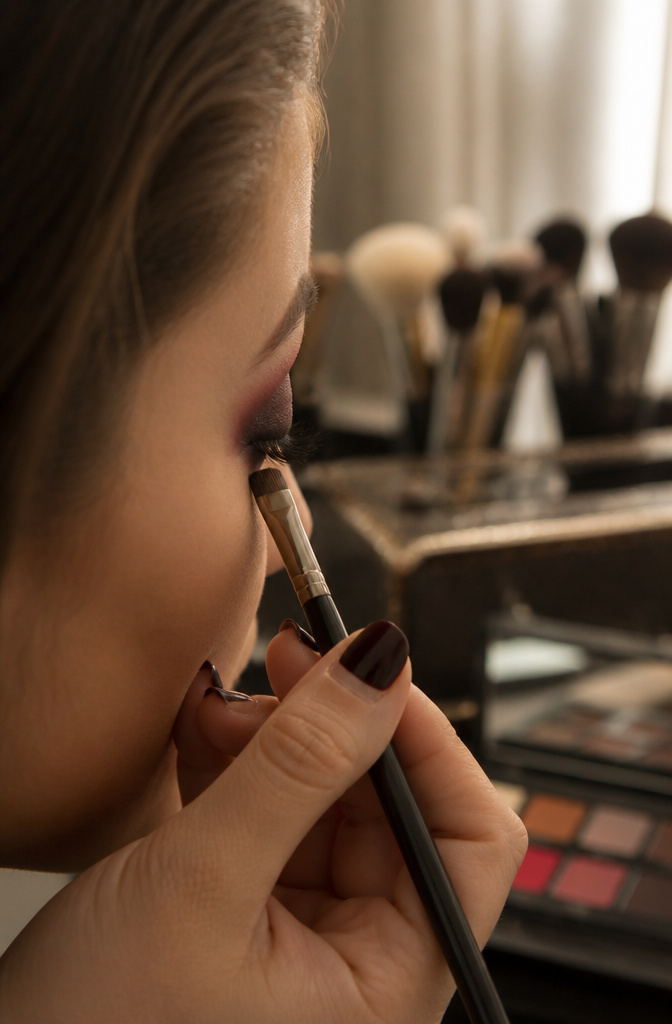 A close-up of black eyeshadow being applied to the lower lash line.