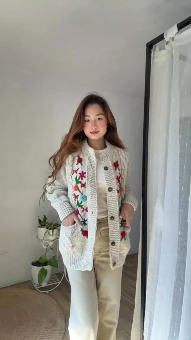 Modest Winter Outfits: 12 Ideas for Cold Days 3 Woman wearing a white floral embroidered cardigan and cream trousers standing in a bright room.