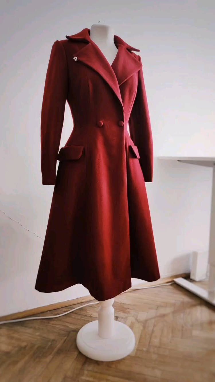 Tailored Wool Coat Styles: 8 Women's Ideas for 2026 8 A long, deep red tailored wool coat displayed on a white mannequin stand.