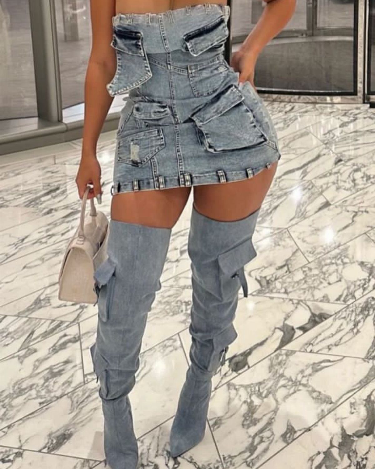 15 Long Boots Outfit Ideas for Cold Months Ahead 3 Person wearing a denim mini skirt paired with matching denim thigh-high boots and a small handbag.