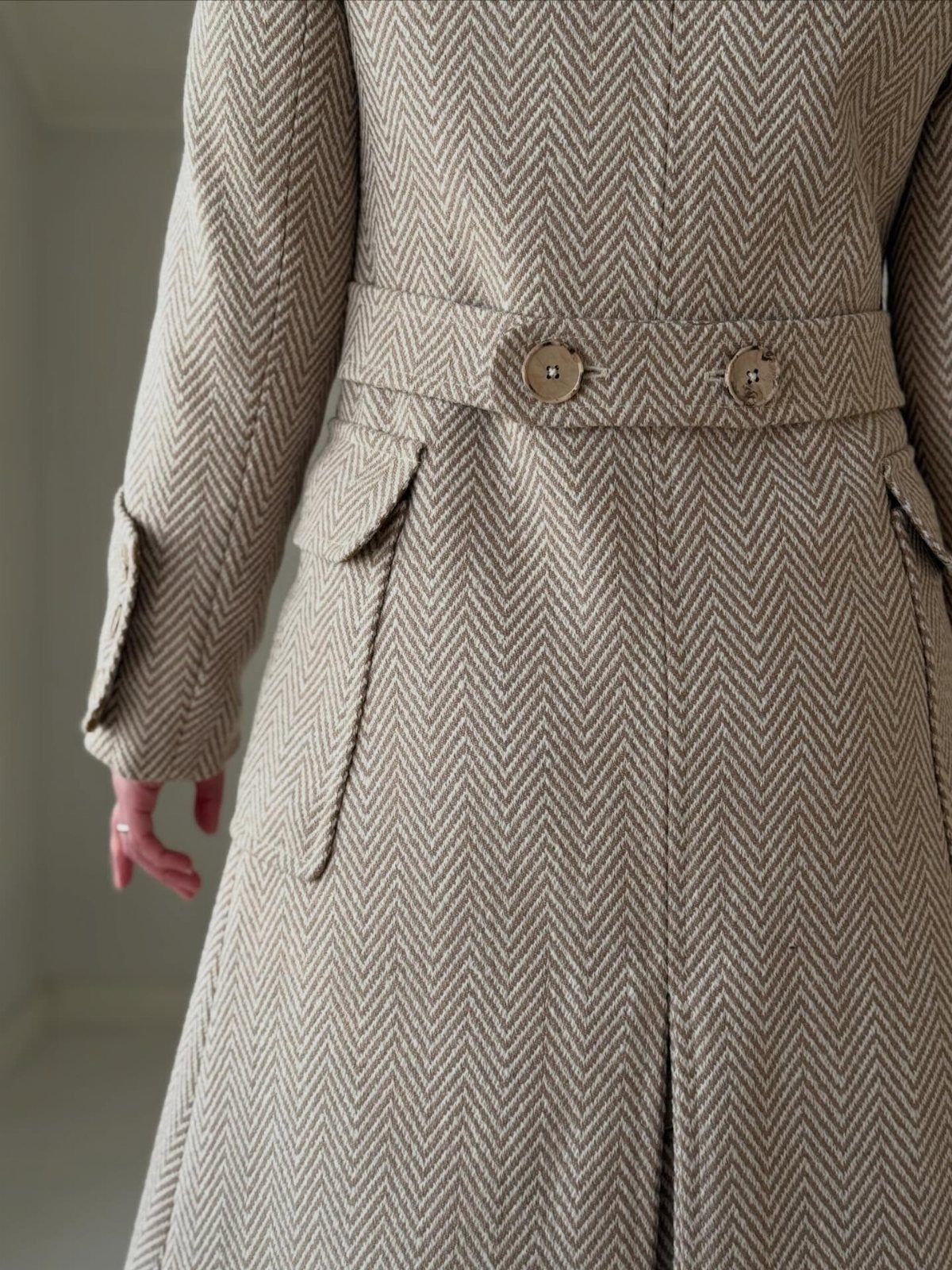 Women's Coat Pattern: 10 Sewing Ideas for Outerwear 4 Back view of a beige herringbone wool coat featuring a belted waist and large patch pockets.