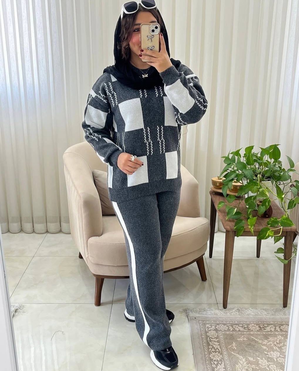 Modest Winter Outfits: 12 Ideas for Cold Days 11 Woman in a grey checkered sweater and matching trousers posing for a mirror selfie.