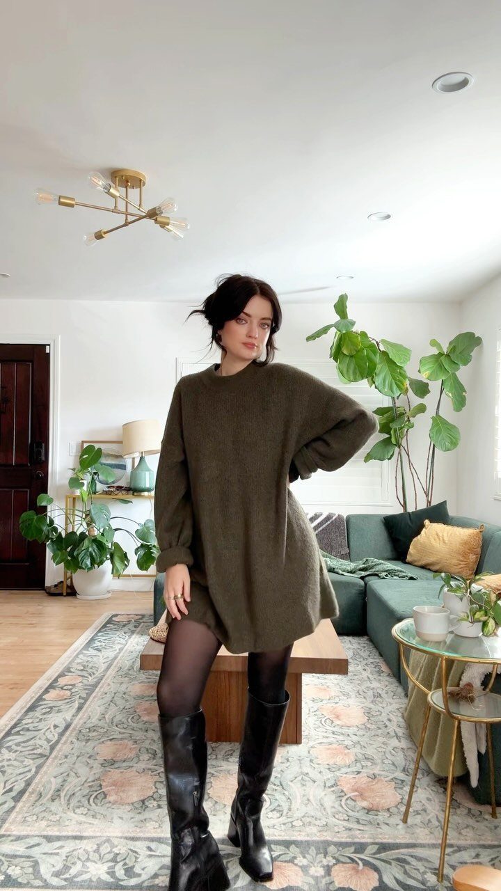 10 Winter Sweater Outfits: From Fair Isle to Full-On Neutrals 6 Woman wearing an oversized olive green crewneck sweater with black tights and tall boots.
