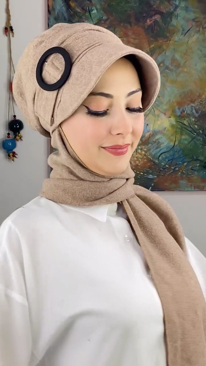 Modest Winter Outfits: 12 Ideas for Cold Days 6 Woman wearing a tan textured winter hijab with a visor and black ring detail.