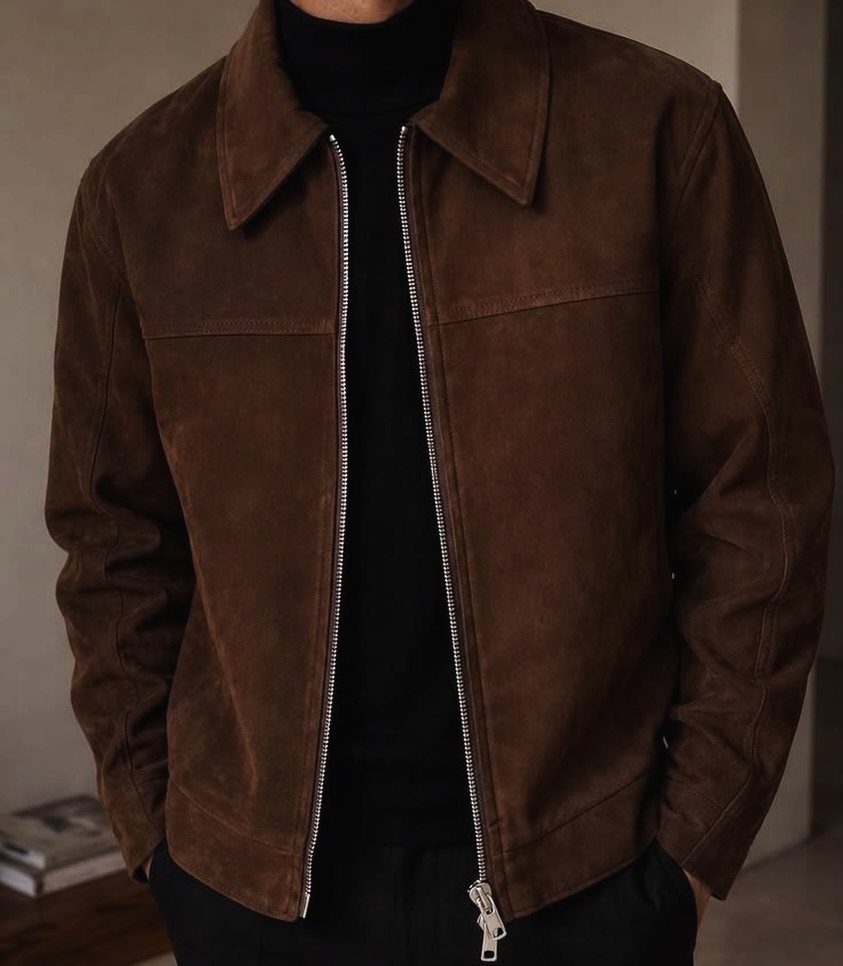 10 Knit Sweater Outfit Ideas for Fall Through Winter 2026 11 A person wearing a brown suede jacket over a black turtleneck sweater and black pants.