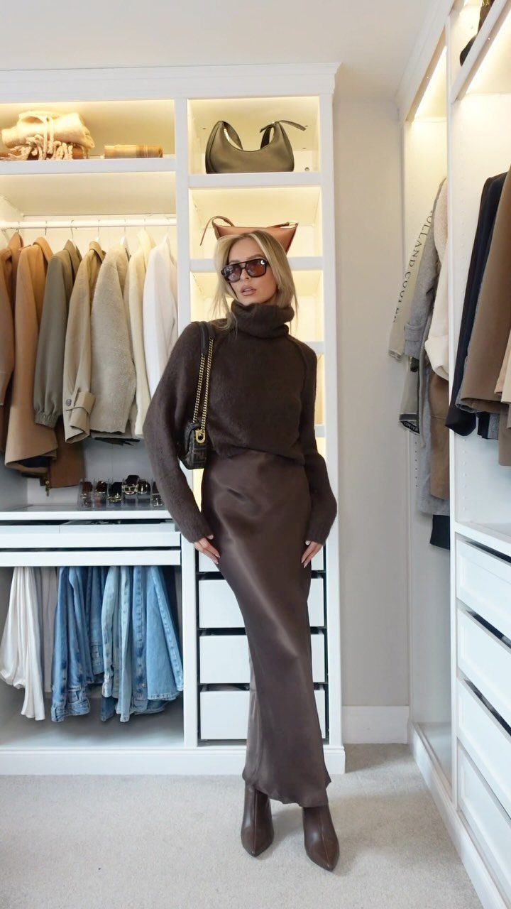 Winter Capsule Wardrobe for Women: 12 Ideas That Actually Work 11 Woman in a brown turtleneck and satin skirt posing in a white walk-in closet.